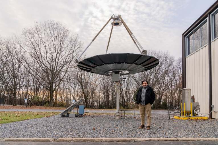 Carlos Romero with the solar thermal concentrator at the Mountaintop Campus of Lehigh University
