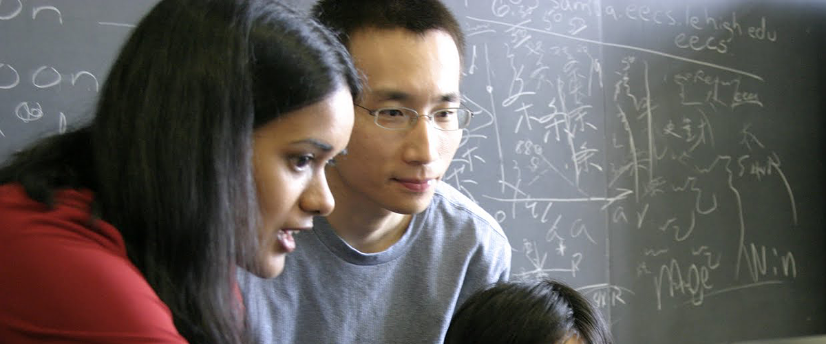 Shalinee Kishore teaching a student with a blackboard in the background