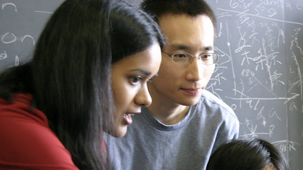 Shalinee Kishore teaching a student with a blackboard in the background