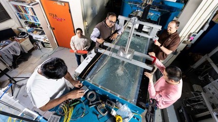 Researchers observe a water tunnel test in the lab